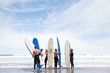 © Connect Images - Group of male and female surfer friends standing on beach with surf boards