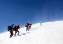 Mountaineering Group Of Tourists Climbing Up The Snow Covered Mo