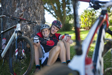 Cyclists Resting By Tree