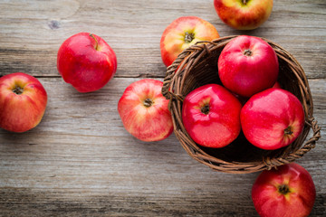 Ripe red apples on wooden background.