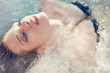 © Connect Images - Close up portrait of young woman lying back in sea