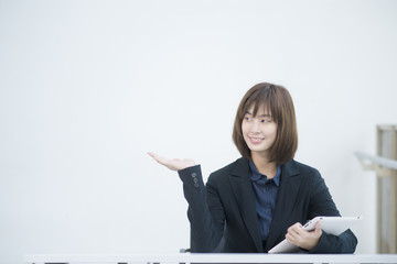 Attractive asian business woman working on tablet computer in wo