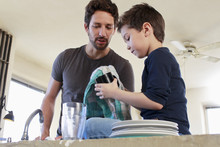 Father And Son Doing Washing Up Chores