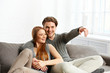 © below - young couple  in living room watch television