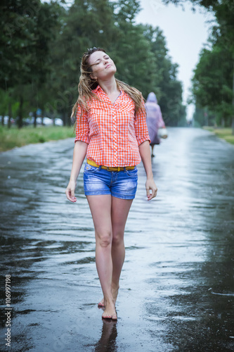 Young Beautiful Blond Caucasian Girl In Shorts And Shirt Walking In The