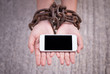 Hands chained holding smartphone.