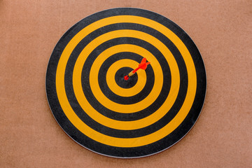 dart hitting a target on brown background