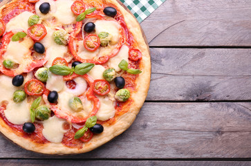 Delicious pizza with cheese and vegetables on wooden background