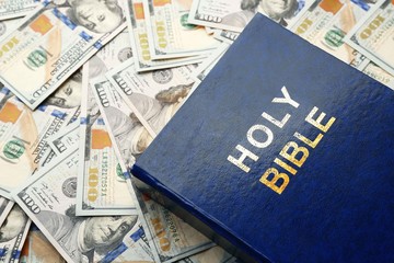 Holy Bible on money background, closeup