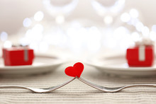 Heart Between Two Forks On A Table Set For Two, Close Up