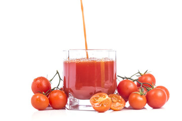 Wall Mural - pouring a thick tomato juice in a glass with many small tomato