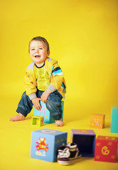 Portrait of a laughing little boy with a bunch of toys