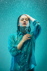 Wall Mural - The portrait of young beautiful woman in the rain