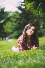 Wall Mural - beautiful smiling woman lying on a grass outdoor.