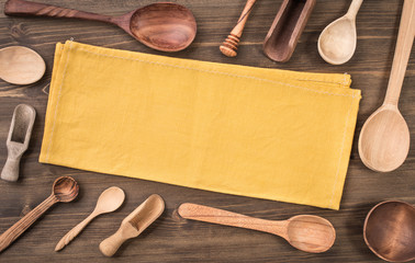 Wall Mural - Yellow napkin and different wooden spoons around