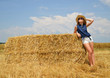 © vencav - Woman with hat resting on a bale of straw on the field
