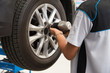 Mechanic working on a car wheel tightening or loosening the bolt