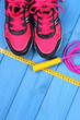 Pair of pink sport shoes and accessories for fitness on blue boards, copy space for text