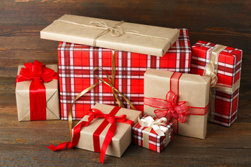 beautiful gifts wrapped with festive ribbon on a brown wooden background