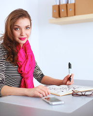 Wall Mural - Young woman writes to diary on a white table