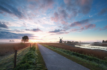 Wall Mural - bike road, windmill in sunrise