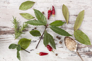 Wall Mural - Bay leaves, spice and condiments wooden background.