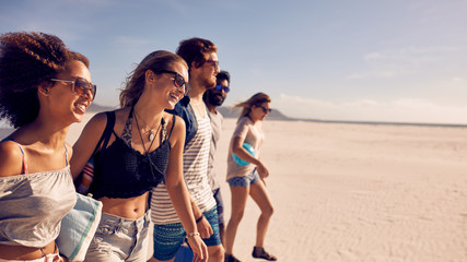 Group of  friends walking on the beach