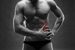© staras - Pain in the left side. Muscular male body. Handsome bodybuilder posing on gray background