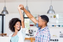 Happy Mixed Race Couple Dancing In Kitchen
