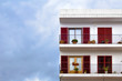 Classic latino spanish building facade with terrace and coloured windows with shutters