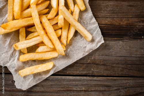 Fotomural French fries on wooden table.