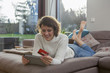 © MA - junge Frau mit tablet computer und Kreditkarte auf Sofa beim online shopping