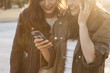 © Monet - Two young women are laughing to see the smartphone