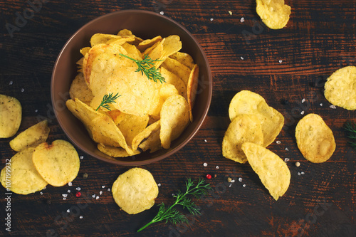 Fotomural Las patatas fritas crujientes en una taza en un fondo oscuro, teñido