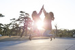 © Monet - Two young women are touching both hands to jump