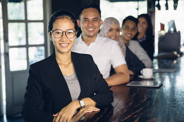 Poster - proud businesswoman standing in front of her team