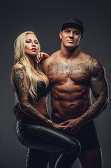 Wall Mural - Modern tattooed couple posing in a studio.