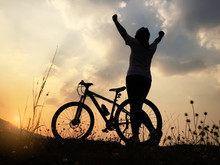 Silhouette Women Showing Her Hands With Bicycle At Sunset