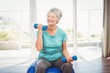 © WavebreakMediaMicro - Smiling senior woman holding dumbbell