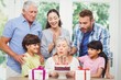 © WavebreakMediaMicro - Granny blowing birthday candles with family