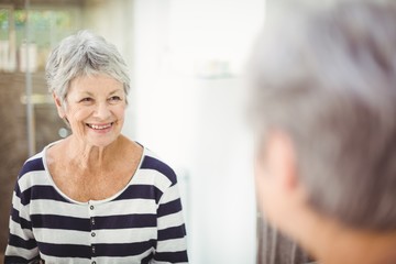 Wall Mural - Reflection of happy senior woman on mirror