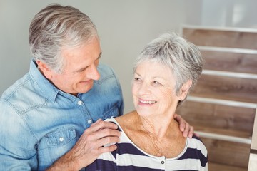 Wall Mural - Cheerful senior couple looking at each other on staircase