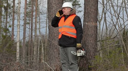 Poster - Lumberjack with chainsaw talking on smart phone near tree