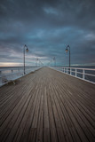 Fototapeta Pomosty - Beautiful landscape with wooden pier in Gdynia Orlowo at sunrise.