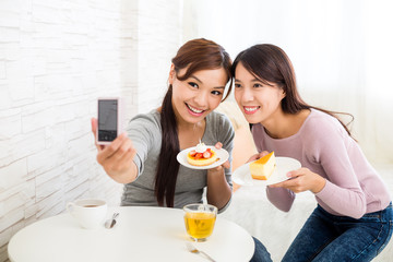 Canvas Print - Two beautiful woman having dessert together in coffee shop