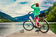 canvas print picture - woman with e-bike resting beside a beautiful lake-e-power 21