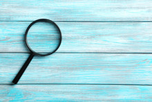 Magnifying Glass On A Blue Wooden Table