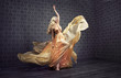 Alluring blond woman dancing in a stylish gown