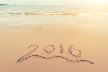 Year 2016 Hand Written On The White Sand In Front Of The Sea