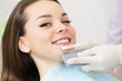 © mintybear - Close up portrait of Young women in dentist chair, Check and select the color of the teeth. Dentist makes the process of treatment in dental clinic office